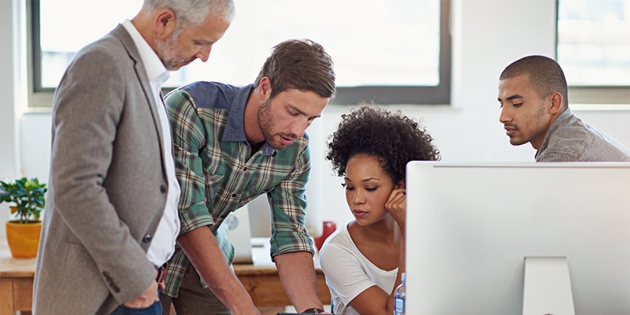 Team of 3 coworkers comparing mobility at a desk together. 