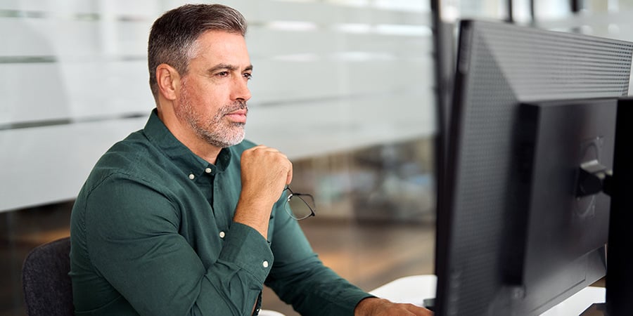 Man In Green Shirt Contemplating Looking At Computer