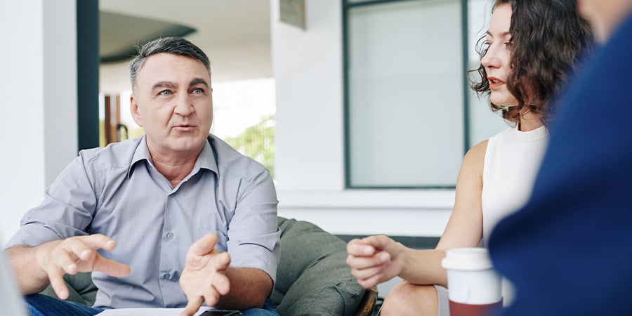 Senior manager talking to his team while in his office