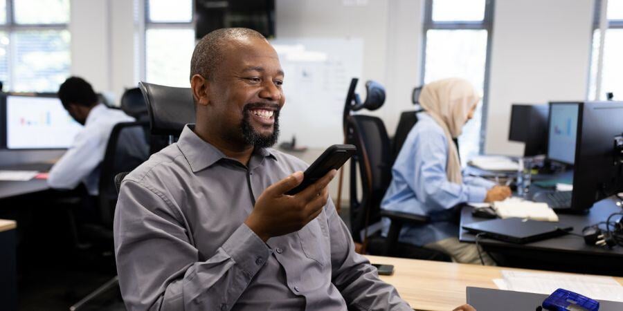 happy african american businessman with smartphone