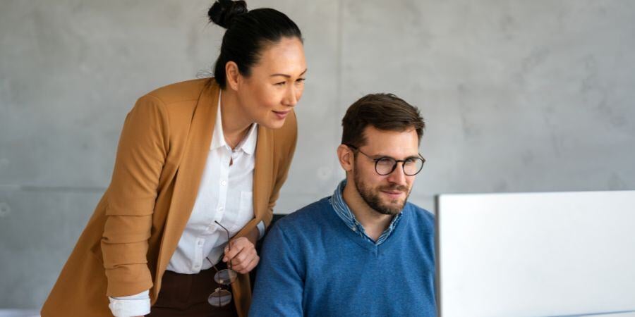  happy businesspeople laughing while collaborating